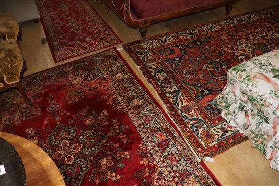Persian red ground rug and two similar smaller rugs